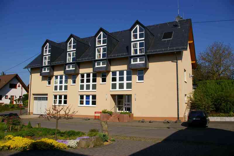 Das Bild zeigt ein gelbes Haus von der Sonne beschienen.